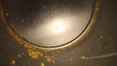 slowly pulling out of the bottom of an empty chip can with many chip crumbs visible - using a wide angle probe lens, getting unique perspectives