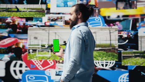young adult holds phone with chroma key screen and connecting on socials