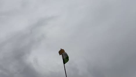 a torn indian flag is fluttering in a cloudy sky