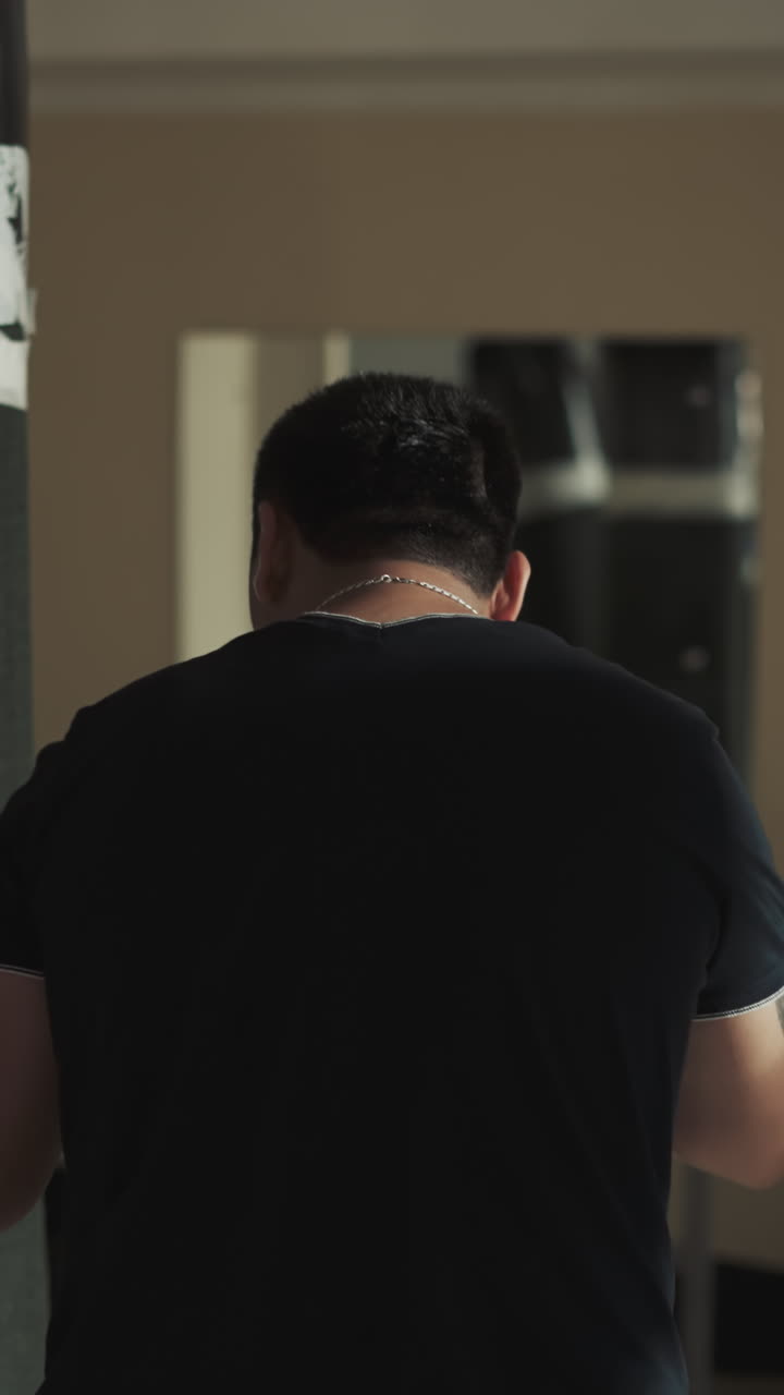 남자 권투 선수는 권투에 참여하여 권투 가방을 강하게 때리기 위해 장갑을 착용합니다. 스포츠 클럽에서 함께 운동하고 체력을 향상시키는 개념