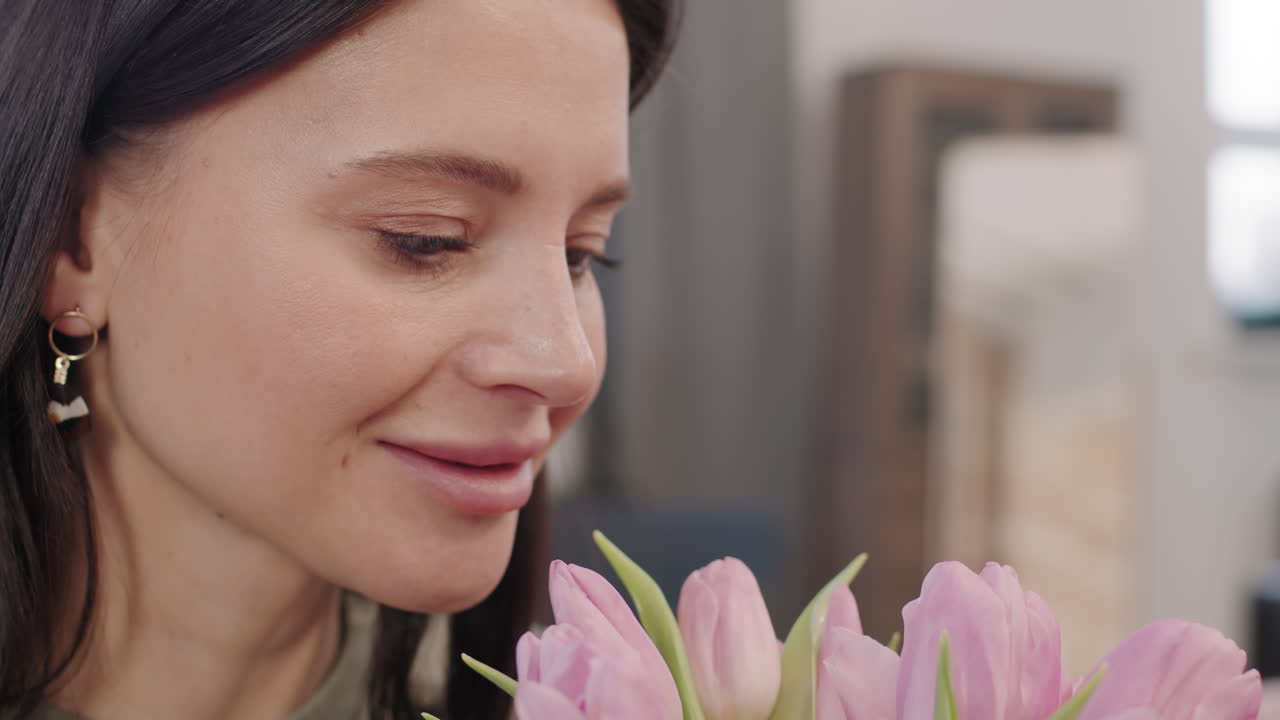 Woman smelling a bouquet of pink tulips