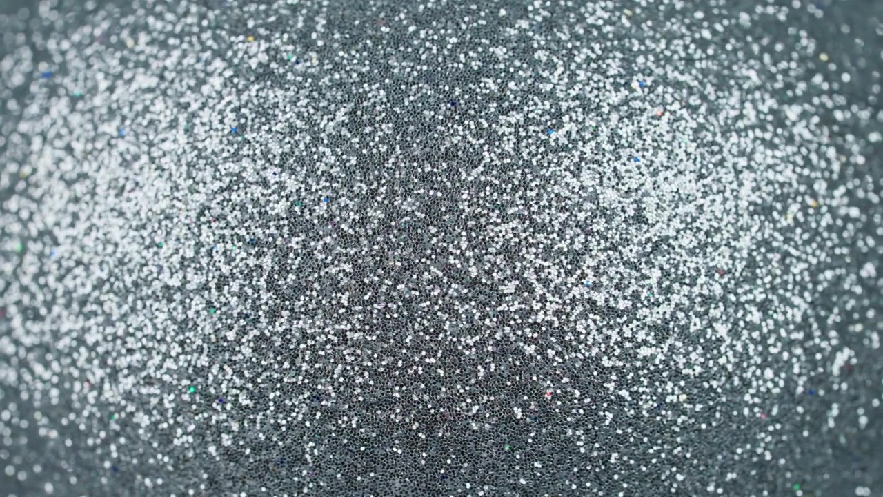 Primo piano di uno sfondo con texture di glitter argentato scintillante.