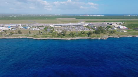 aerial flight over blue caribbean sea towards airport in santo domingo during sunny day, dominican republic