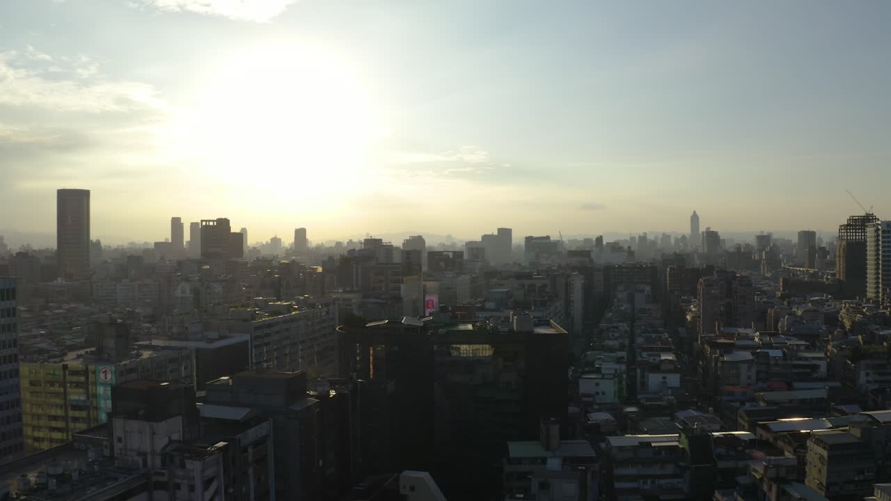 Tomada aérea de drone avançando sobre a cidade de Taipei ao pôr do sol