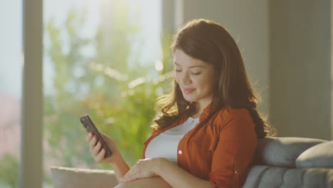 pregnant woman using smartphone at home
