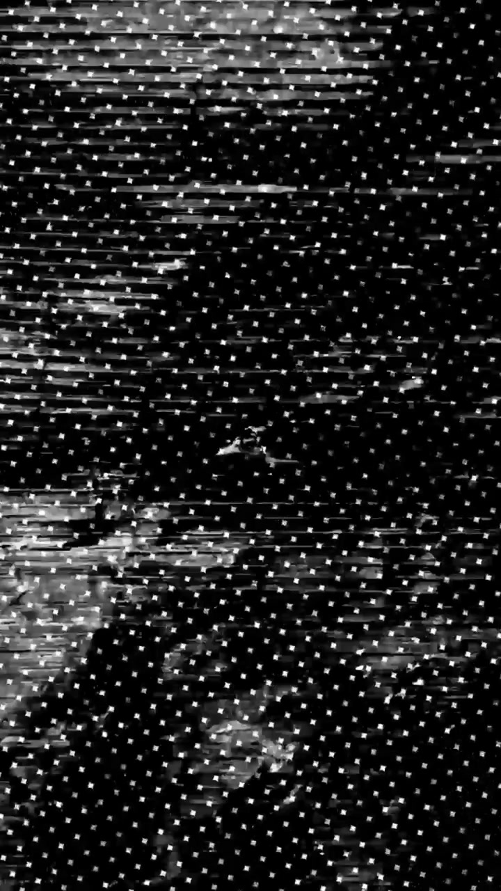 Abstraktní glitch efekt s bílými tečkami na černém pozadí