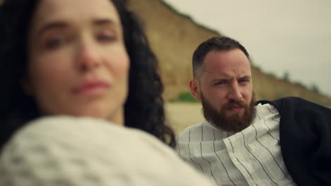 multiethnic couple looking camera on sea beach. two lovers enjoy laying outside.