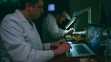 male robotic engineer using laptop at desk 4k