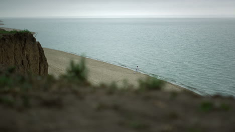 Malerische-Aussicht,-Wilder-Strand-Mit-Unbekanntem-Mann,-Der-Kampfsportarten-Trainiert,-Bewölkter-Tag.