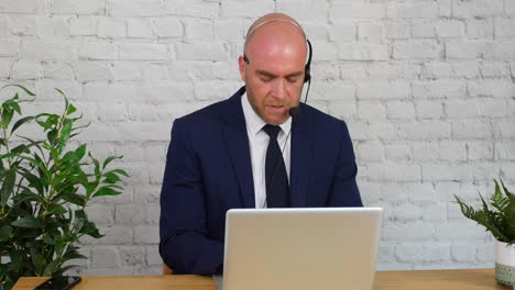 a businessman giving customer support using a headset and laptop computer