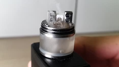 applying heat on the coils on the rda over the dark background