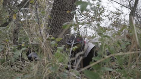 jugador de paintball arrastrándose en plastunno disparo en cámara lenta