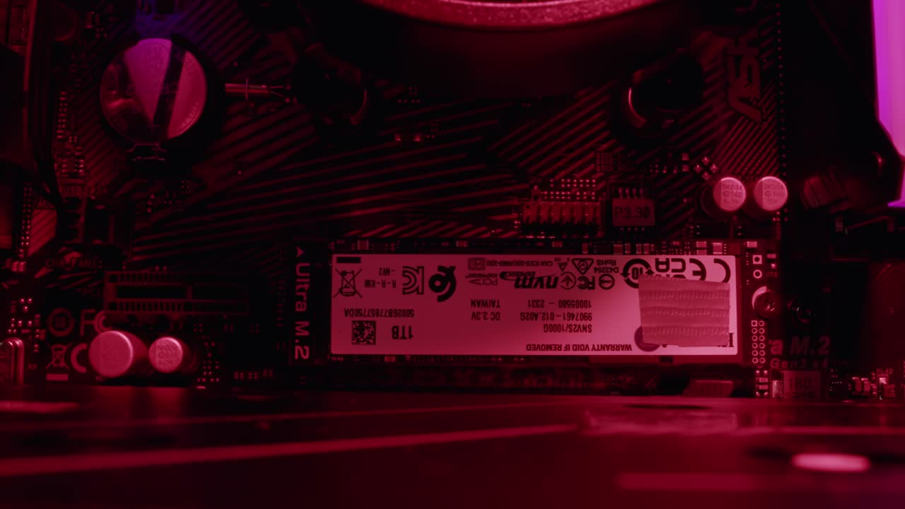 Close-up of a computer motherboard with M.2 SSD and red lighting