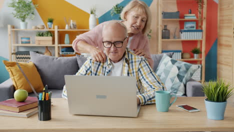 senior couple using laptop together at home