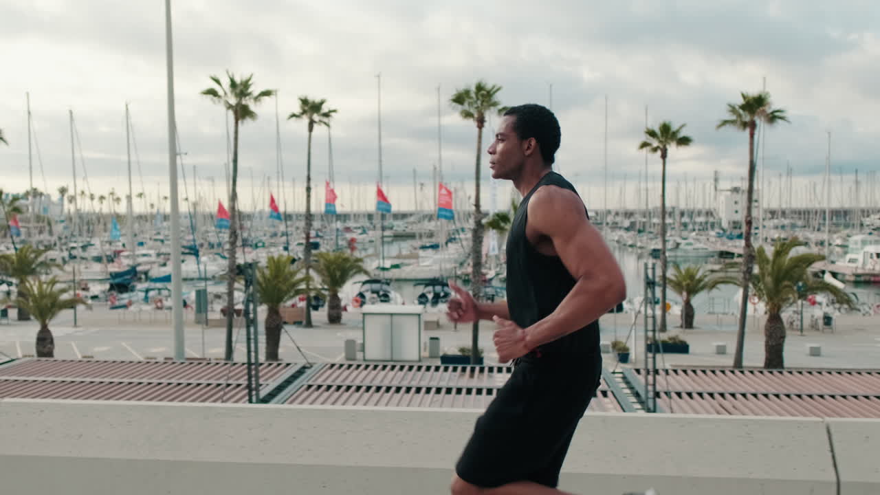 Fit Black Man Runs by the Marina