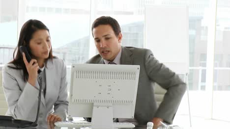 dos colegas serios trabajando en una computadora
