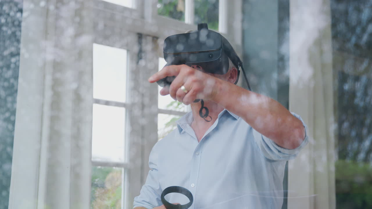 Vista attraverso una finestra: uomo maturo indossa un visore per la realtà virtuale e tiene in mano controller da gioco.