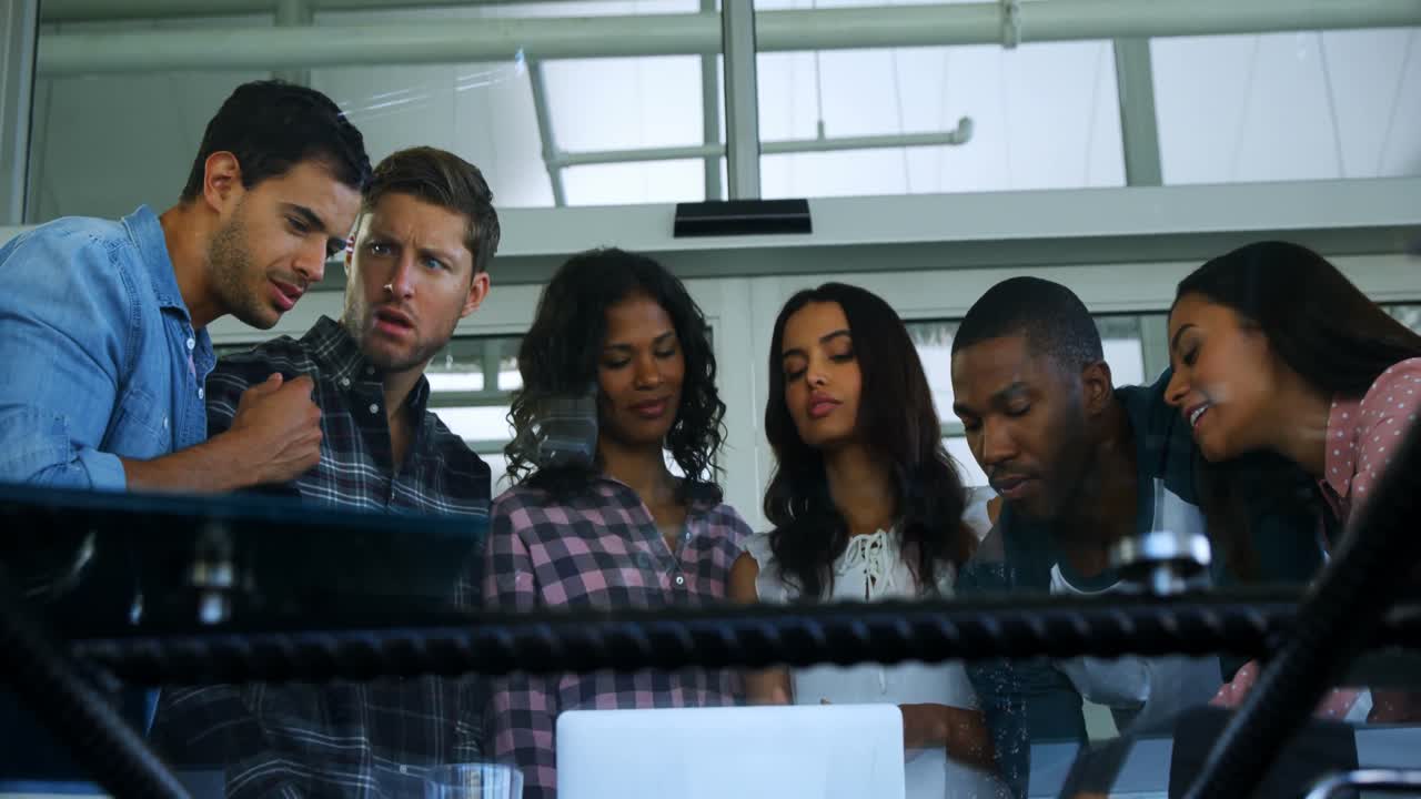 grupo de ejecutivos discutiendo sobre una computadora portátil