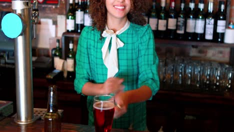 Barmaid-pouring-beer-in-a-glass-at-bar-counter
