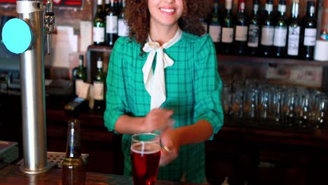 barmaid pouring beer in a glass at bar counter