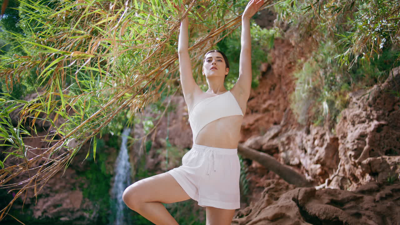 열대 절벽에서 요가를 연습하는 평온한 소녀. 자연의 조화를 즐기는 여성