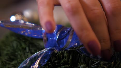 woman making a fir advent wreath for christmas eve and decorating it, diy craft decoration, winter traditions, seasonal holidays, hands close up handheld shot