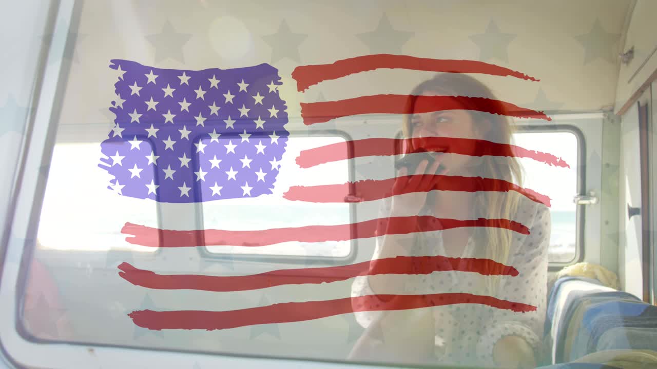 animación de la bandera estadounidense dibujada sobre una mujer caucásica en el coche usando un teléfono inteligente en la orilla del mar