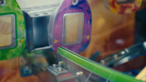 una moneda entra con éxito en la ranura mientras que otra falla en la máquina de arcade de monedas en el área de juego del parque de atracciones