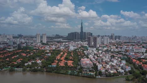 aerial hyperlapse flying in to modern city aerial view on sunny day with interesting clouds and shadows, waterfront houses and high rise buildings