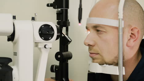 Optometrist examining male patient. Patient man examining eyes by optometrist using phoropter