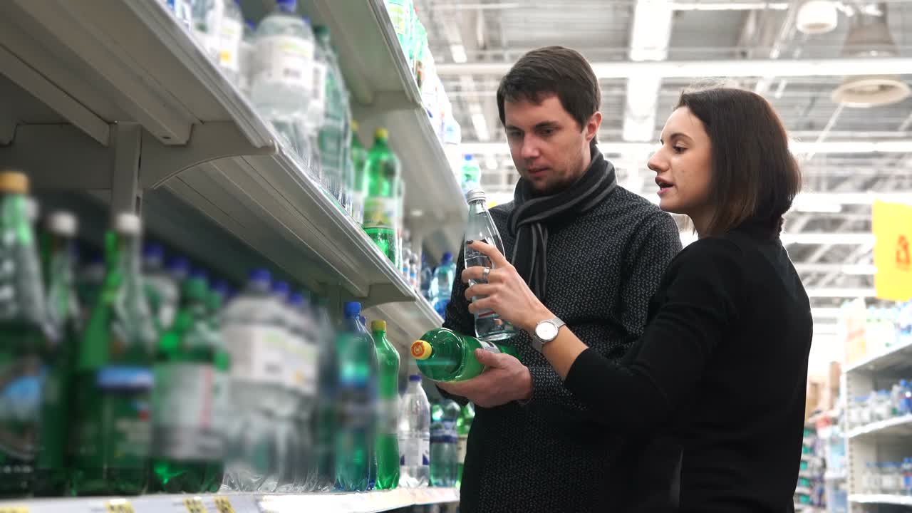 Couple Shopping for Water Bottles in a Grocery Store