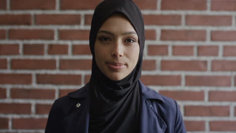 portrait independent young muslim woman turns head looking happy wearing hijab headscarf in brick wall background culture islam slow motion