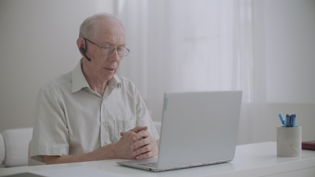 aged man is using video call on notebook sitting at home for communication with colleagues self-isolating and remote working