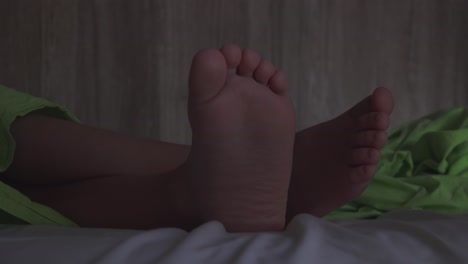 closeup of boy's feet, barefoot child sleeping in bed