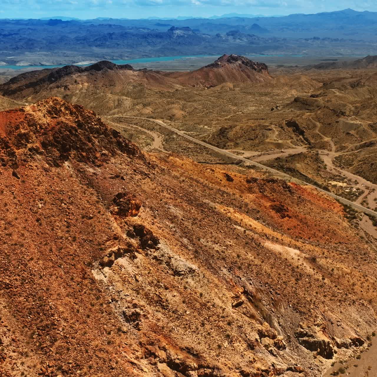 Paisagem montanhosa e seca em um terreno rochoso no deserto de Mojave. Rochas arenosas marrons sob perspectiva aérea