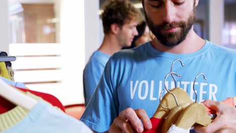voluntario seleccionando ropa del estante de ropa