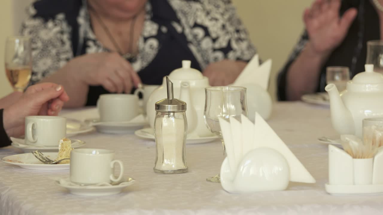 저녁 식사 테이블 에 앉아 케이크 를 먹는 노인 들