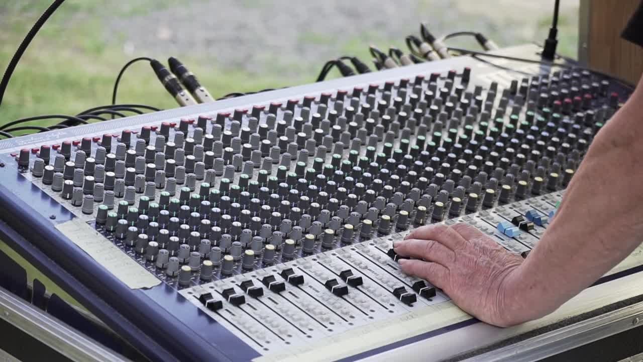 Sound mixer and hands at live concert, slowmo closeup