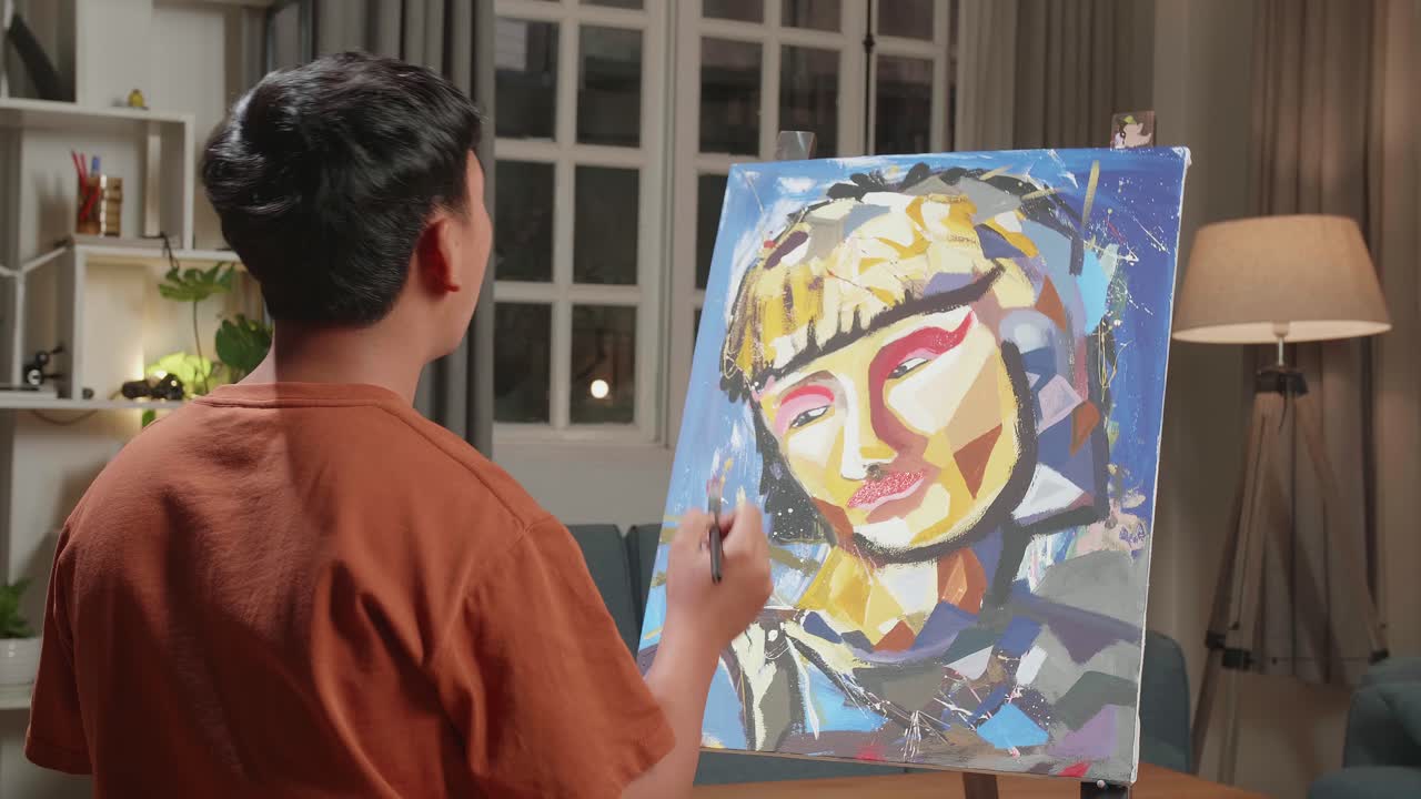 Hind View Of An Asian Artist Boy Holding Paintbrush Mixed Colour And Thinking Before Painting A Girl'S Hair On The Canvas