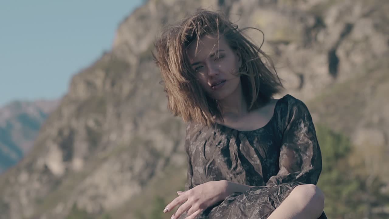 ⁇ 은 드레스를 입은 예쁜 여자가 언덕을 따라 느린 동작으로 포즈를 취한다