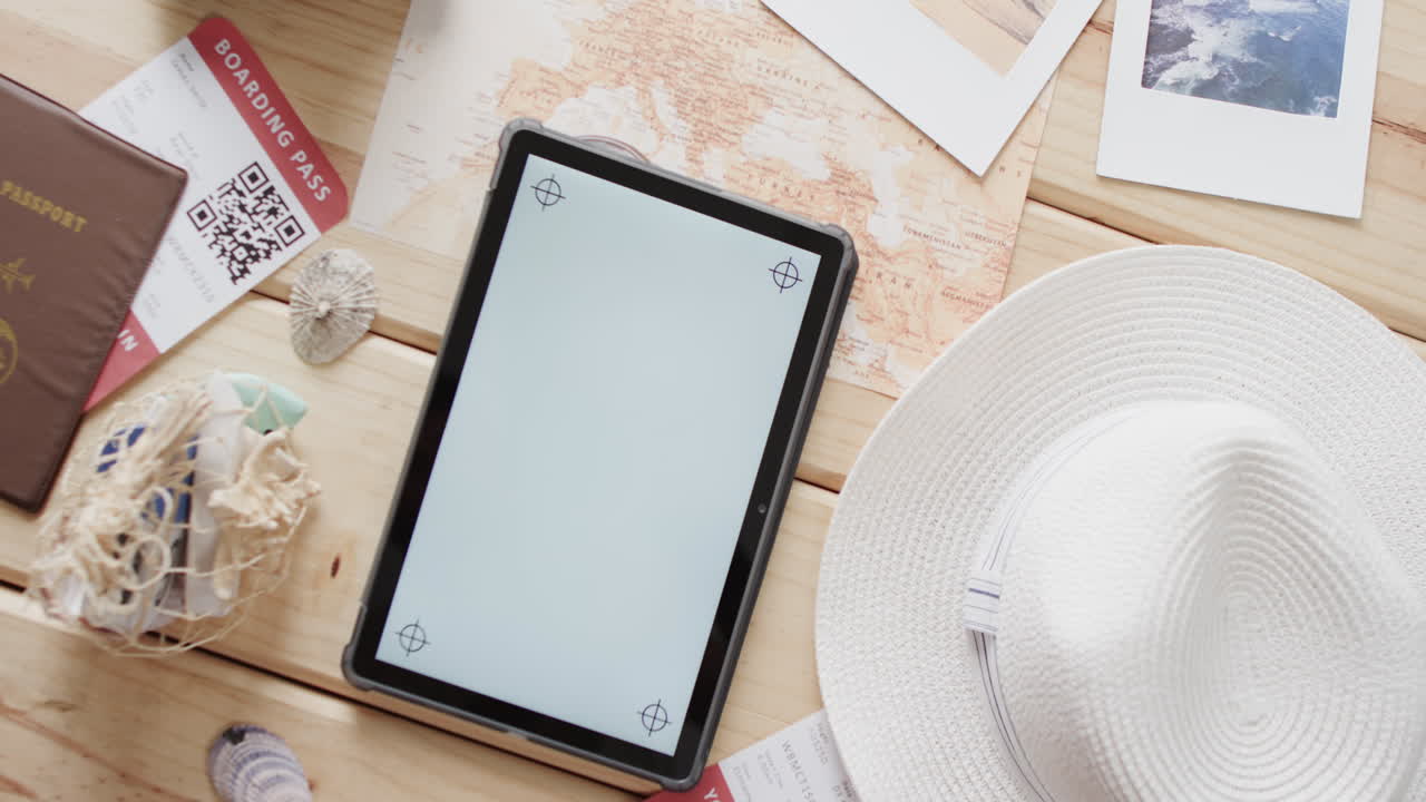 tableta plana con espacio para copiar, pasaporte y sombrero de sol sobre fondo de madera.