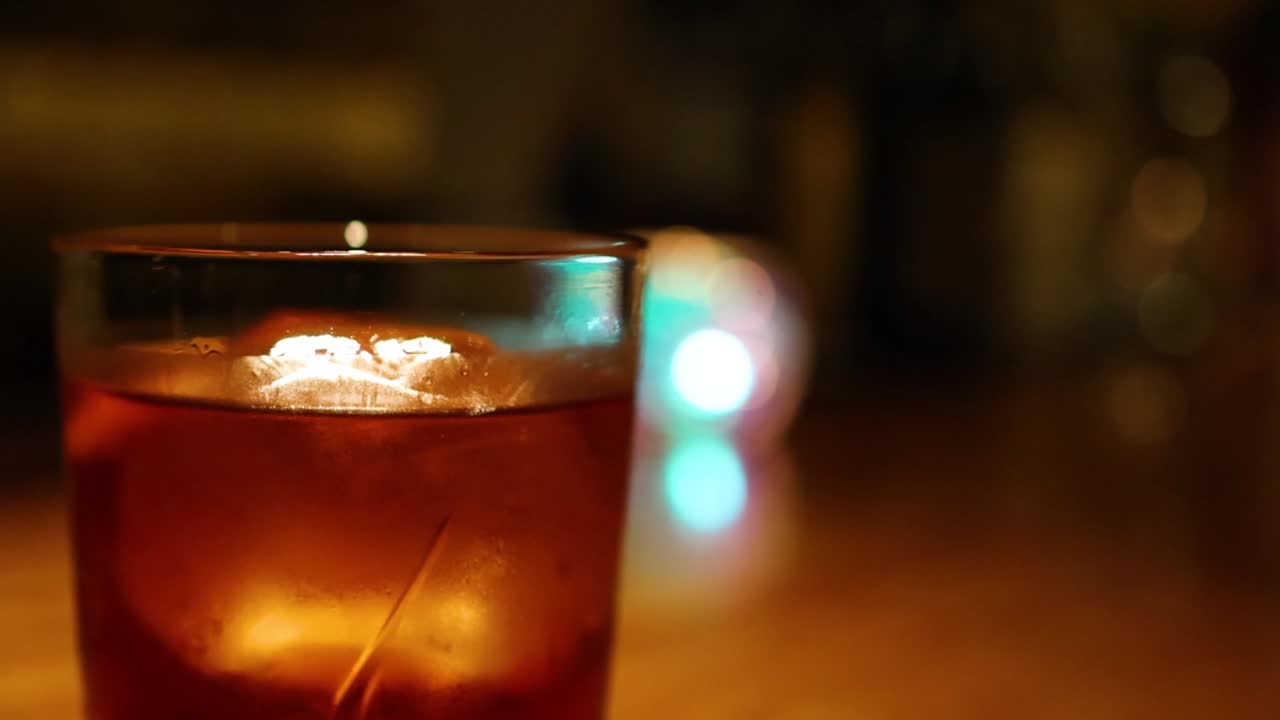 Man Holding a Cocktail at a Bar at Night