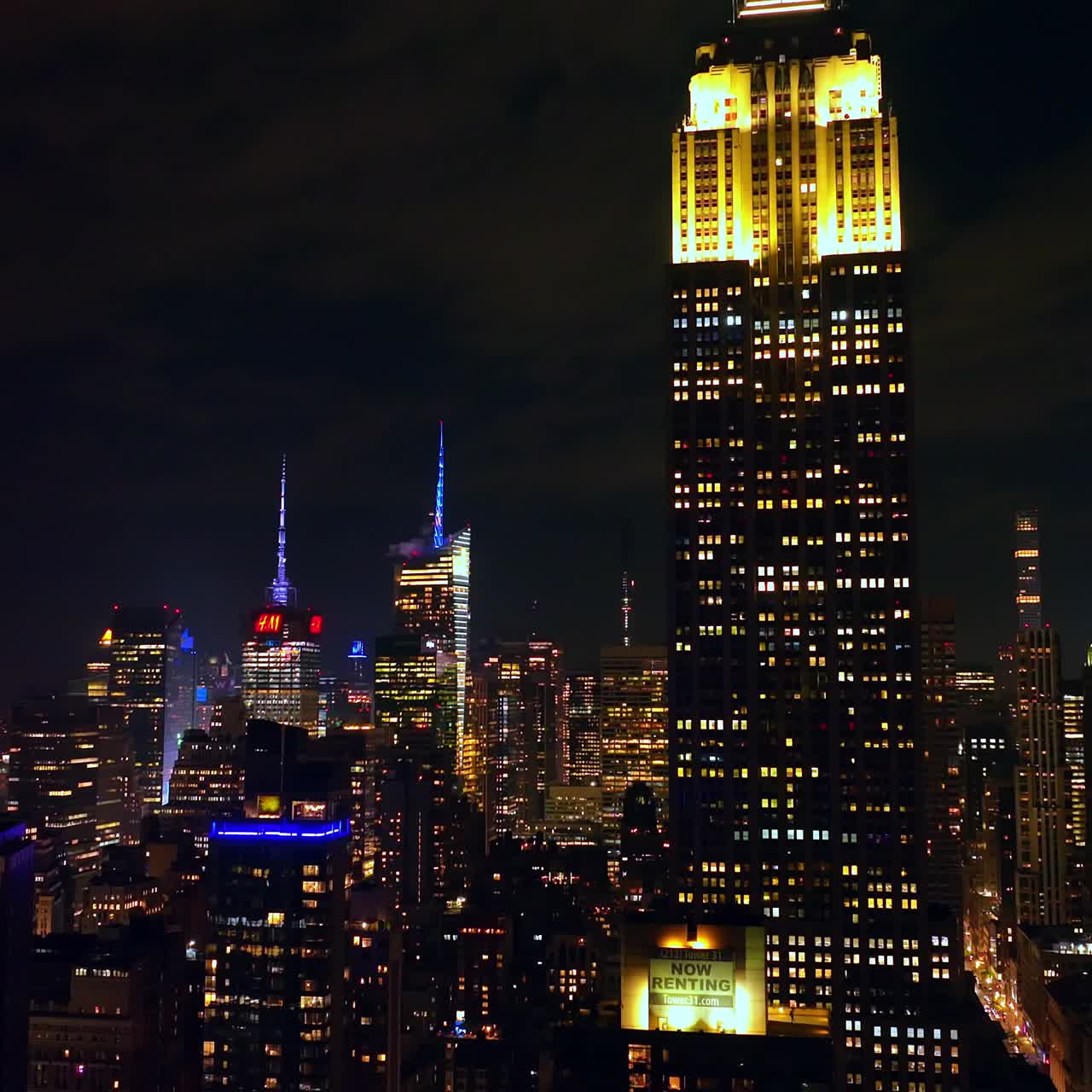 Bright shining tops of outstanding New York skyscrapers. Panorama of amazing metropolis at night