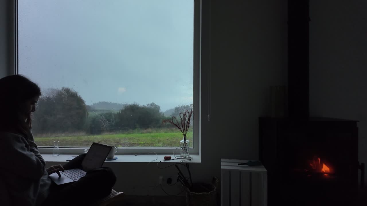 Slow motion view of a woman working remotely on a laptop in a quiet indoor setting