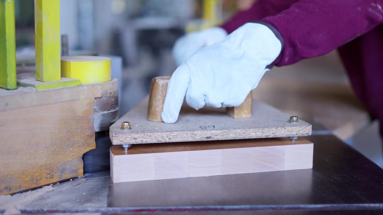 Woodworking machine shaping wooden board in workshop