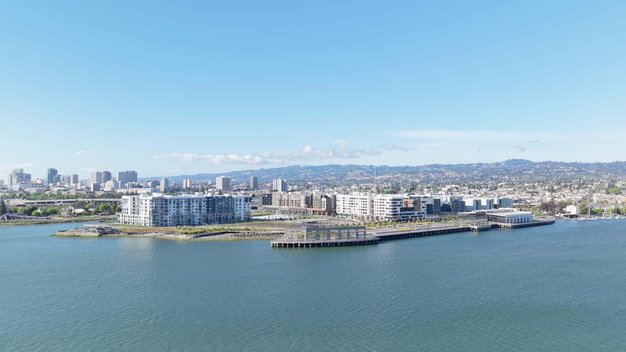 Oakland's waterfront buzzes with life as the aerial view reveals its vibrant mix of shops, marinas, and city backdrop.