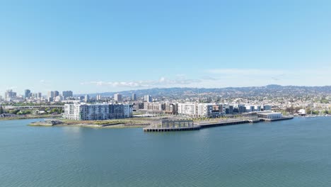 oakland's waterfront buzzes with life as the aerial view reveals its vibrant mix of shops, marinas, and city backdrop.