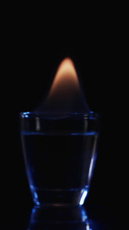 vertical video of lit alcohol flames and copy space on black background