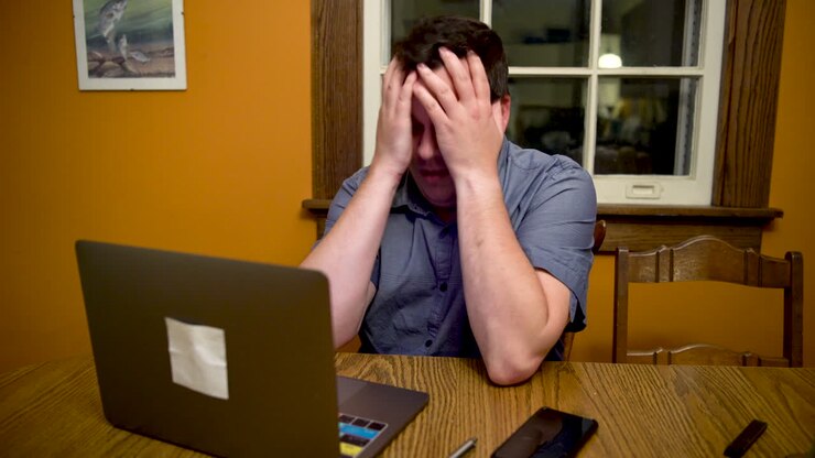 Man very stressed out about something on his laptop computer
