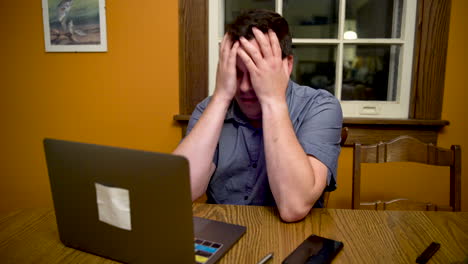 man very stressed out about something on his laptop computer